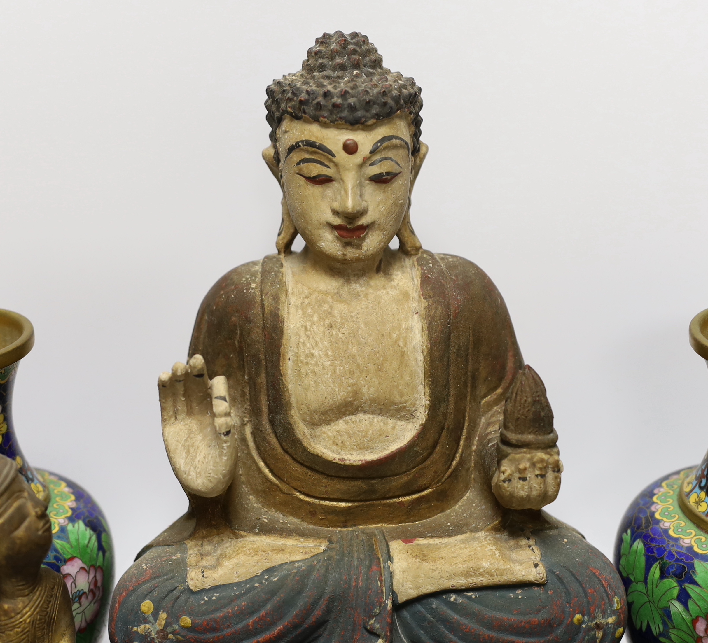 A pair of Chinese cloisonné enamel vases and a bowl on stand, two soap stone lion dogs, a carved and painted Buddha, a deity and four wooden stands, Buddha 33cm high